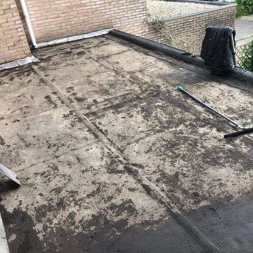 Schoonmaken van een plat dak in Leerdam